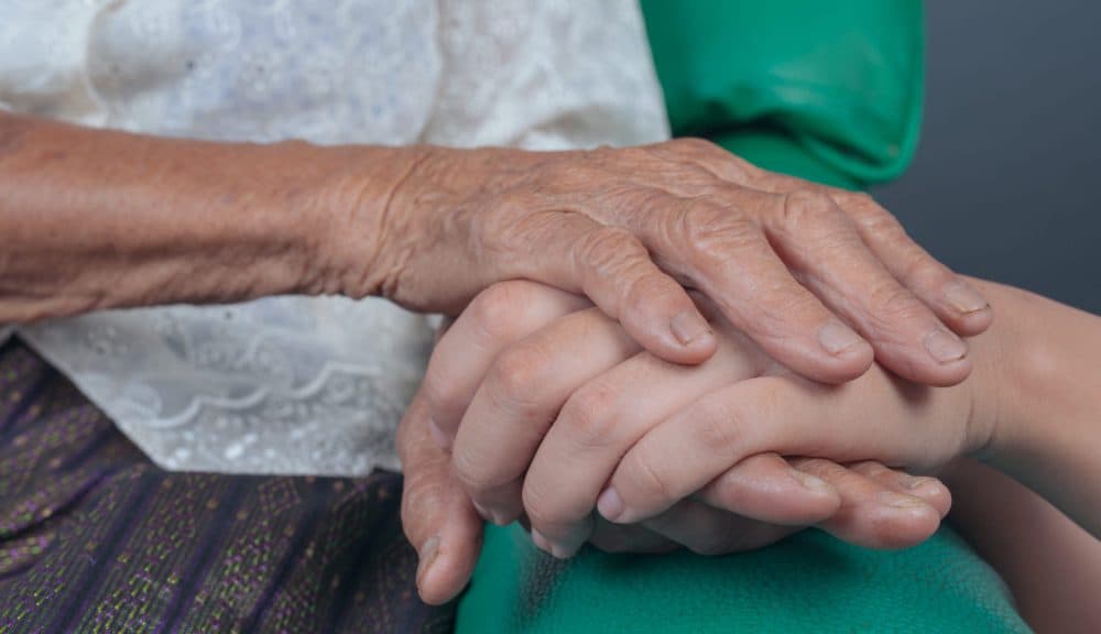 Young woman holding an elderly woman’s hand. Infrared lasers could treat Alzheimer’s – study