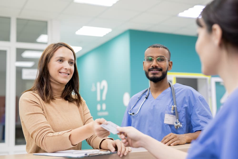 Patient giving credit card to receptionist in clinics to pay for medical service An NHS case study in IT transformation