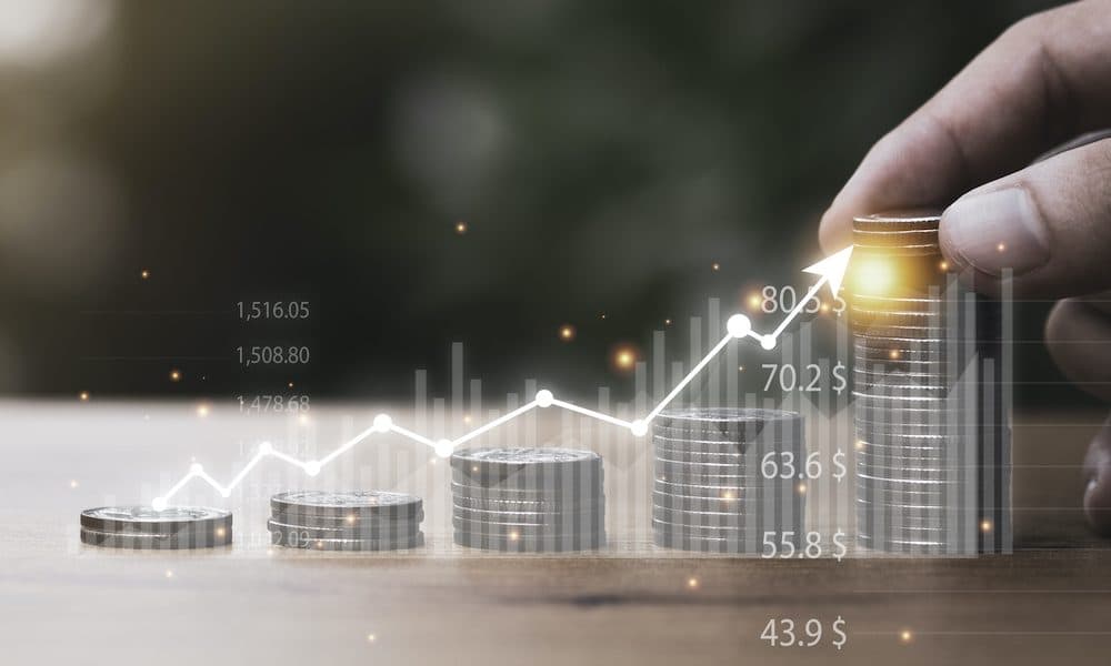 Hand putting coin stacking with virtual trend graph on table. Business investment growth and profit increase concept. Doctorlink reports triple-digit user growth