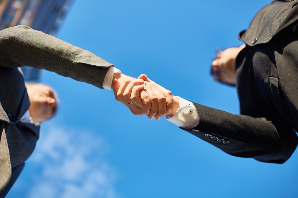 Handshake of partners and blue sky above Torbay Council enhances adult social care services with new System C software