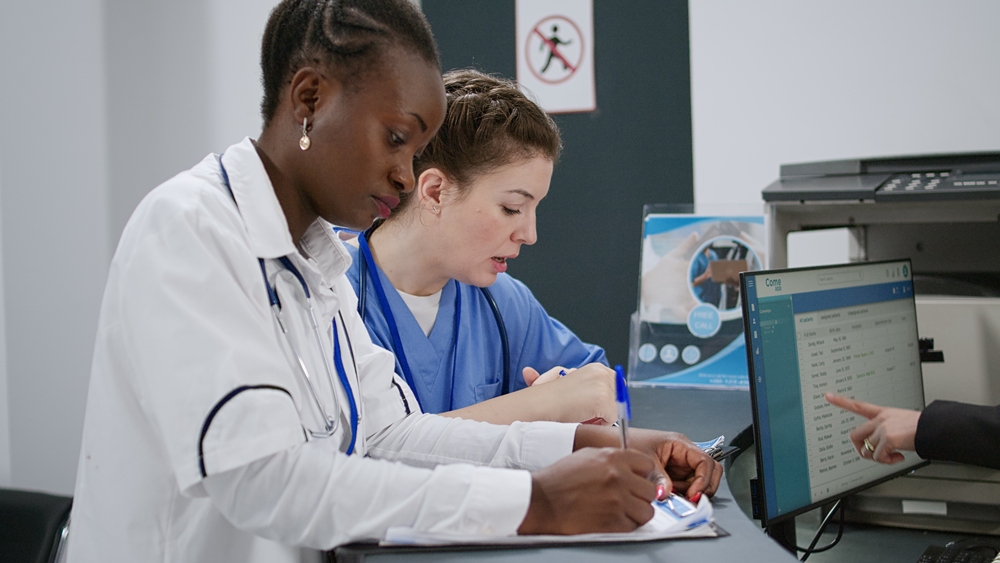 Multiethnic team of specialists analyzing report papers Diagnostics delivery: How Magentus supports the NHS Medium-Term Planning Framework